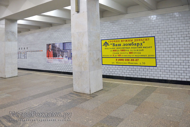 Станция "Беляево". Станционный зал. Реклама на путевой стене.